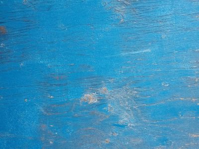 Blue lines meet the wood, faded form holds the surface, art stays in the grain