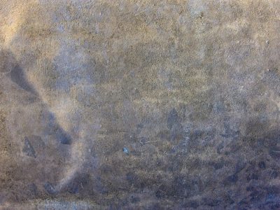 Blue paint fades away, orange rust eats through the skin, grit holds the surface