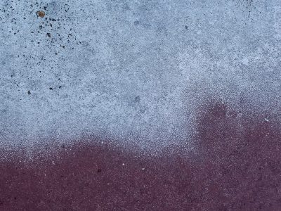 Pale blue dust descends, maroon surface waits below, speckles mark the line