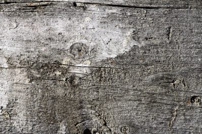 Blue paint peels away, brown rust eats the heavy steel, flakes drift on the grit