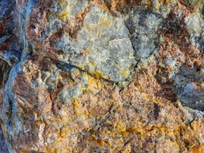 Blue shards meet the frost, orange veins bleed through the field, grit marks the fracture