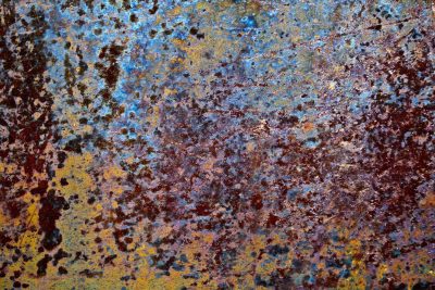 Blue skin holds the dark, orange dust meets the surface, grit marks the finish