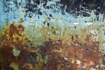 Azure paint fractures, orange rust claims the metal, age peels back the skin