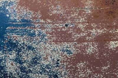 Blue skin meets the rust, orange veins bleed on the steel, grit marks the finish