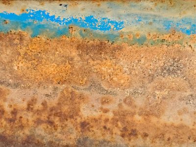 Blue strips meet the rust, orange waves bleed through the skin, grit marks the finish