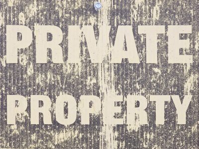 Bold words on the sign, yellow streaks the faded brown, weather claims the board