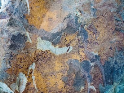 Bright curves twist in light, mineral grains hold the field, jagged forms meet the edge