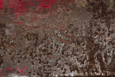 Brown rust eats the steel, orange veins bleed on the plate, time leaves a thick mark