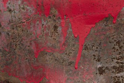 Red paint drips like blood, rust consumes the metal plate, time wears down the steel