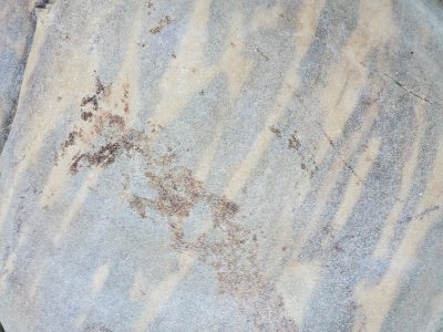 Tan bands drift slowly, mineral lines trace the path, aged stone holds its form