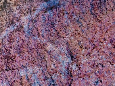 Purple crystals glow, blue light streaks the ancient rock, textured stone reveals