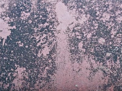 Dark spots on the red, mottled skin on the metal, grit holds the surface