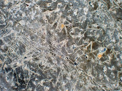 Etched lines in stone, jagged marks trace the table, time carves the grit