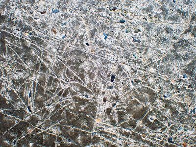 Scars on ancient stone, white dust fills the jagged lines, earth carved deep by time