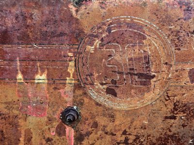 Faded thirty marks, heavy rust eats through the steel, orange claims the face