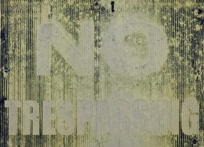 Faded yellow plea, black lines bleed across the sign, quiet warning stands.