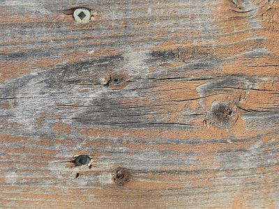 Fading stain on wood, brown grain flows through the board, time holds the finish