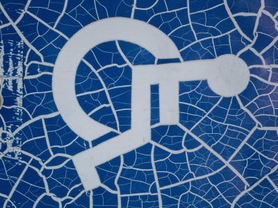 Blue paint webs apart, white lines break in tiny shards, time cracks the symbol