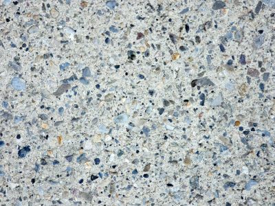 Smooth stones locked in place, grey sand binds the scattered gems, rough path worn by time