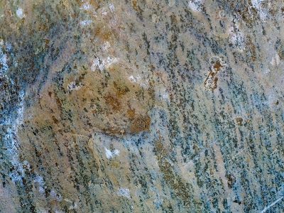 Grey stone holds the light, speckled grains of blue and brown, ancient earth remains