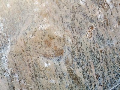 Pale grains meet the sun, ancient minerals align, stone holds years of weight