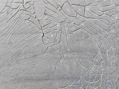 Grey skin starts to peel, deep lines map the heavy wear, paint breaks from the heat