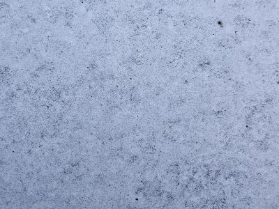 Pale blue surface waits, dark grains dust the frozen ground, silence in the stone