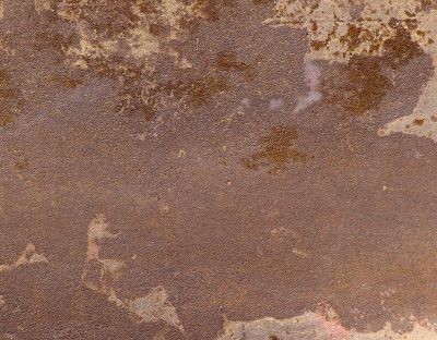 Rust coats weathered steel, rough surface wears earthy tones, time paints metal red