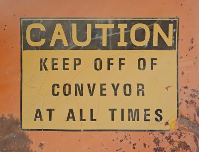 Metal throat waiting, A yellow voice holds the line, Danger hums below.