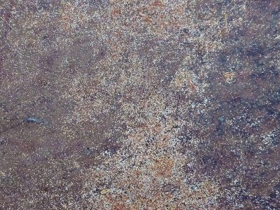 Orange dust on steel, fine grains mark the heavy plate, rust claims the finish