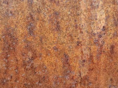 Orange dust on the steel, rough pits scar the heavy plate, rust claims the surface