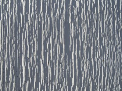 White drips frozen still, deep shadows mark vertical, rough ridges remain