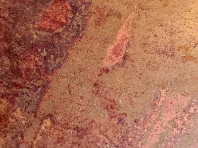 Red blooms on the steel, orange dust fills every pit, metal turns to earth