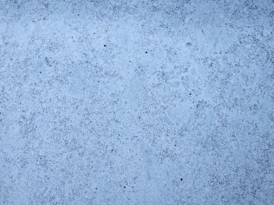 Pale blue fills the frame, tiny black specks mark the skin, grit holds the cold face