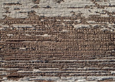 Pale blue turns to grey, tiny rust spots mark the skin, grit holds the pattern