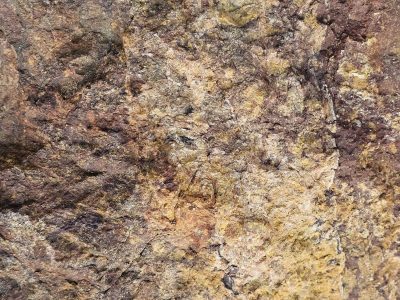 Pink crystalline grains, grey mineral veins trace the stone, grit holds the pattern