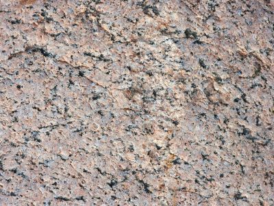 Pink veins in the rock, black specks scatter on the stone, grit holds the pattern