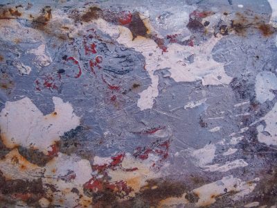 Purple fields of rust, red spots bleed on faded blue, steel turns into dust