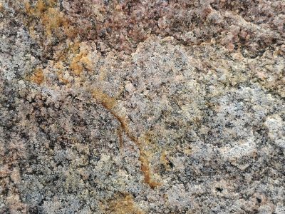 Red crystals emerge, coarse grain flows across the stone, time leaves heavy marks