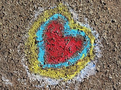 Red heart on the ground, blue and yellow trace the edge, chalk meets heavy grit