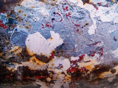 Red roses on the wall, faded floral marks the paper, pattern holds the age