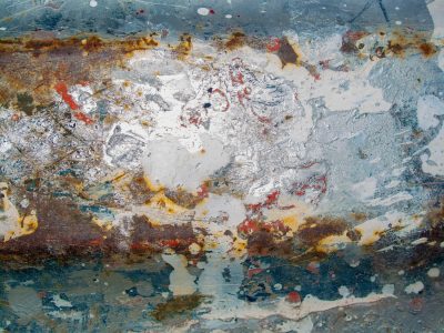 White paint flakes away, orange rust eats through the steel, blue stains mark the years