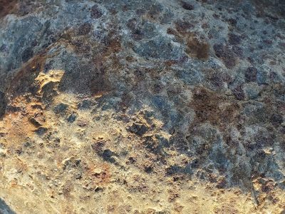 Red spots on the stone, purple minerals emerge, grit holds the pattern
