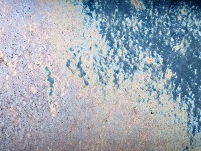 Blue paint wears away, rust blooms on the weathered plate, time fades every mark