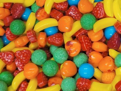 Sweet sugar glimmers, fruity shapes in rainbow hues, crunchy shells of joy