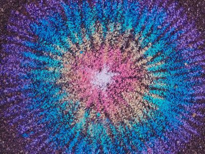 Bright dust paints the ground, starburst of neon pigment, rough stone holds the spark