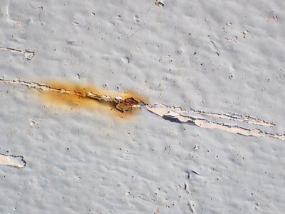 Silver wood holds the grain, grey marks trace the board, time wears the finish