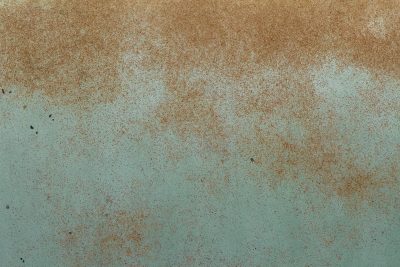 Teal paint starts to fade, orange dust across the steel, iron meets the air