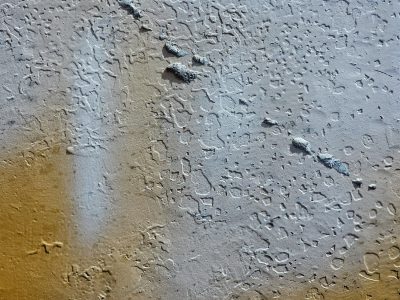 Tan dust meets the grey, pitted skin on the hard wall, grit marks the finish