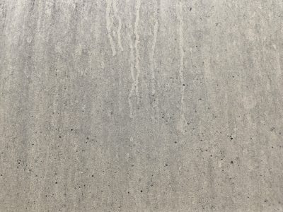 Tan pits on the wall, black streaks mark fading paint, grit meets the rough board